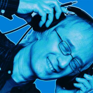 Blue-filtered portrait of Hans S. from DAVID Systems with closed eyes holding headphones above his head