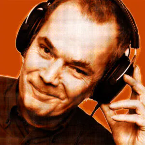 Orange-filtered portrait of Wolfgang from DAVID Systems smiling, wearing headphones and holding them with his left hand